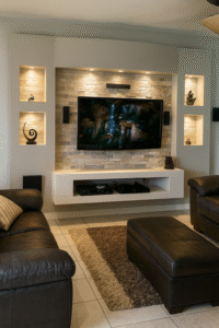 Modern media wall with stacked stone feature, built-in recessed shelves with LED lighting, floating white TV unit, and mounted flat-screen television in a contemporary living room.